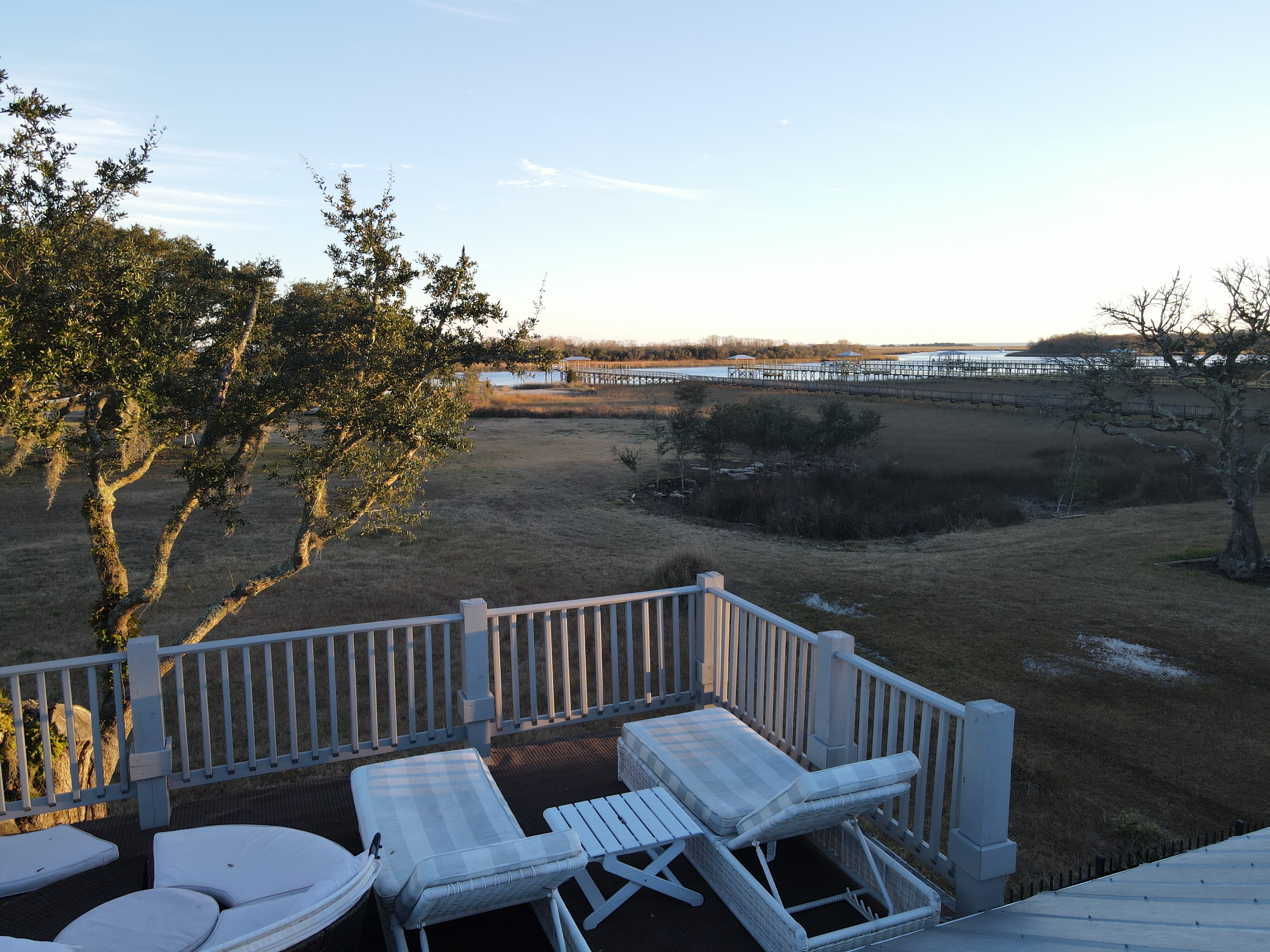 Elevated view from the upper deck across Spanish moss-draped oaks and the Intracoastal at golden hour