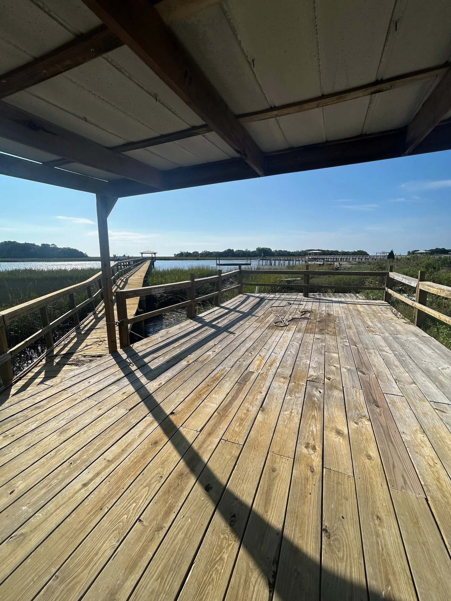 Covered dock platform with peaked roof overlooking the tidal creek
