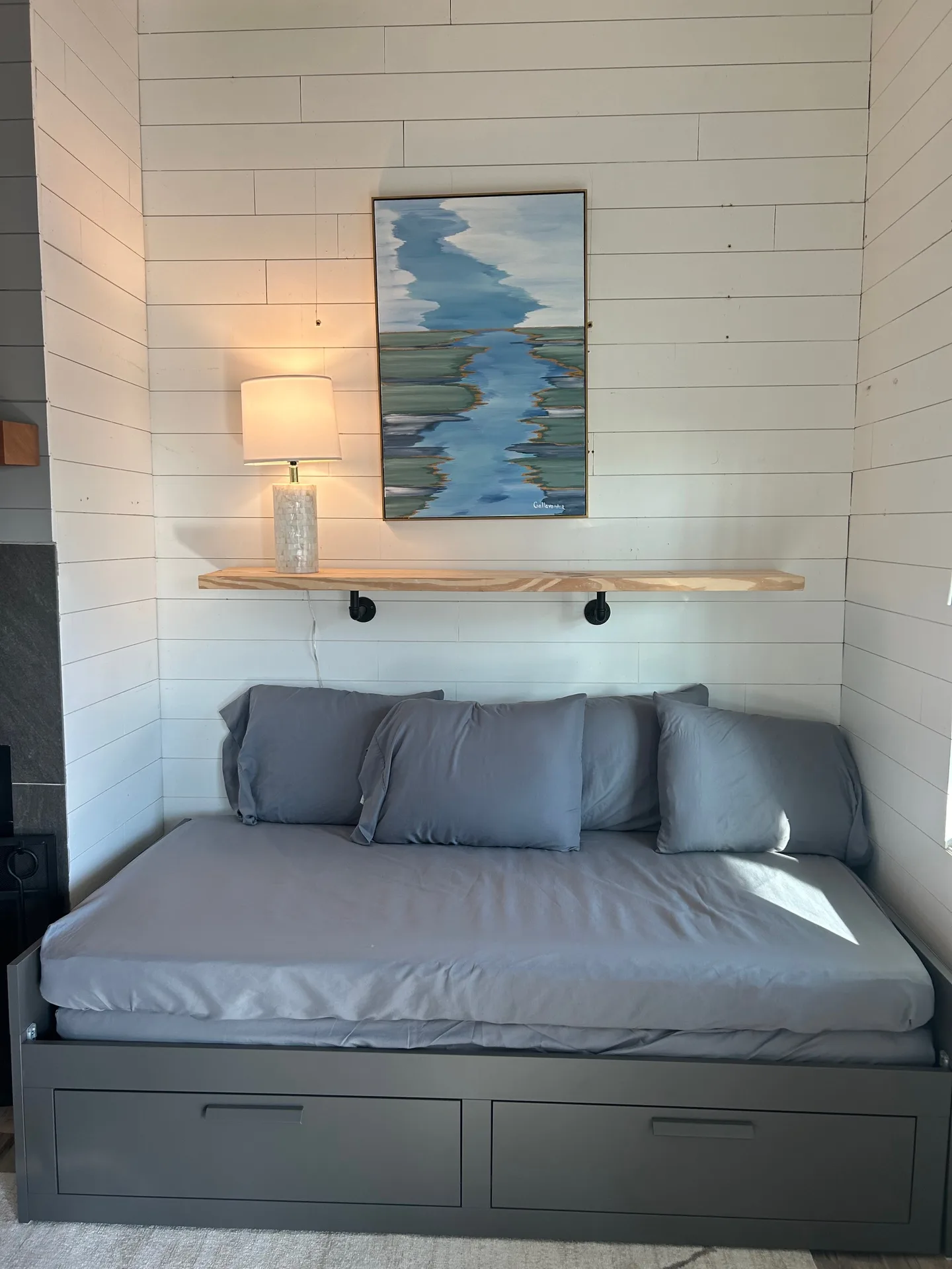 Daybed alcove with shiplap walls, live-edge shelf, and marsh painting by local artist